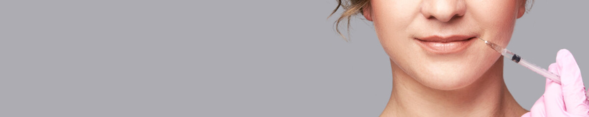 Lips injection at spa salon. Doctor hands. Pretty female patient. Beauty treatment. Healthy skin...
