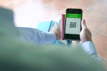 Vaccinated traveler using digital health passport in mobile phone for travel during Covid-19 pandemic.