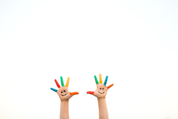 Naklejka premium Banner view of children hands in colorful paint with funny smile face isolated on white background