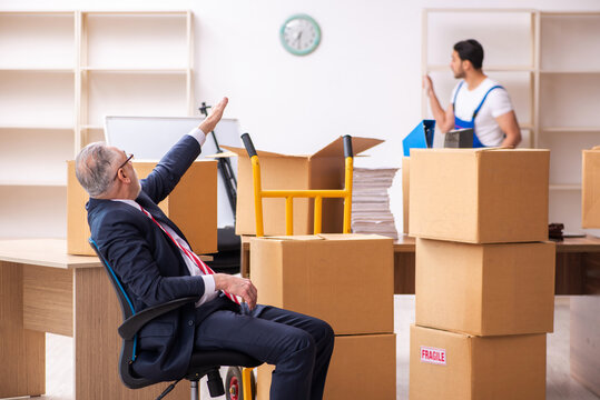 Old businessman and young contractor in relocation concept