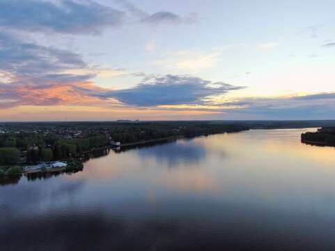 Aerial view sunset on the river. Colorful clouds are reflected in the water. Beautiful panorama of nature at sunset.
