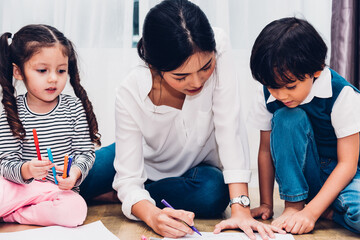 Family happy child kid girl kindergarten paint drawing on peper teacher education with mother mom