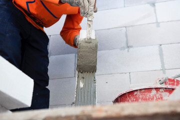 Professional workers use plaster to glue walls in private homes. Masonry, repair and foam construction