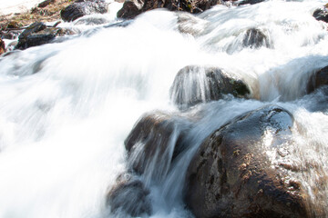 a stream. mountain river with big stones. a rushing stream.