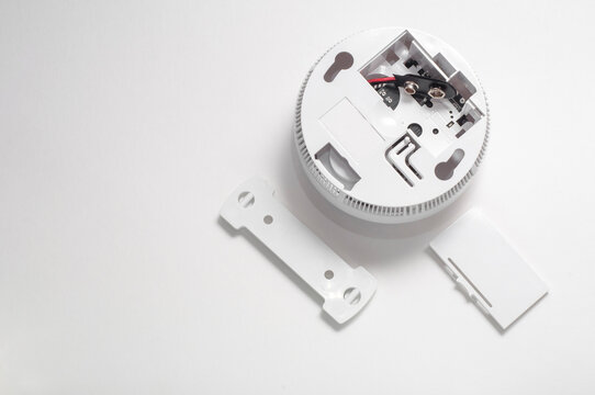 Smoke detector on a white background with an open battery compartment