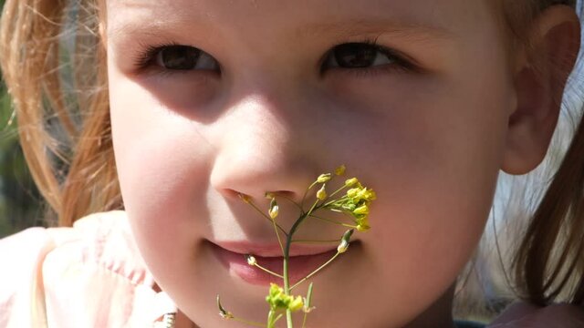 Portrait of little girl with spring wildflowers  outdoors. Kids being kids concept. Authentic photo of child. Spring vibes