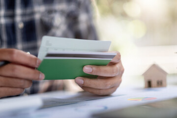 Man hands holding saving account passbook with calculator, account and saving for home loan concept