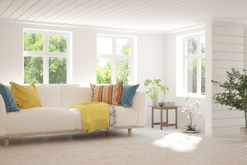 Fototapeta premium White living room with sofa and summer landscape in window. Scandinavian interior design. 3D illustration