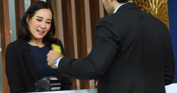 Friendly receptionist woman working at desk in hotel lobby
