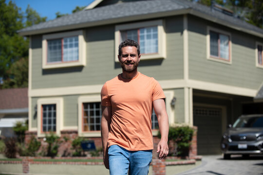 Portrait Of Confident Man Standing Outside New Home. Successful Real Estate Agent Purchasing House For Investment Purpose. Happy And Handsome.