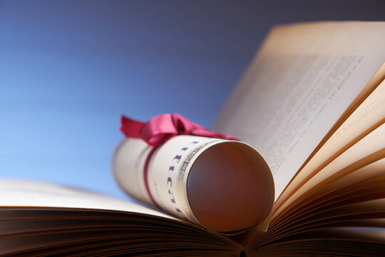 scroll of certificate on open book