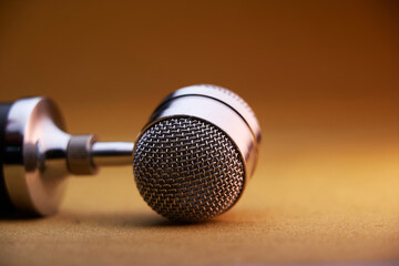 selective focus of vintage microphone on brown background