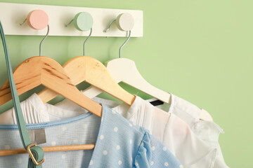 Hanger with stylish clothes on color background, closeup