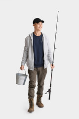 Teenage boy with fishing rod and bucket on white background