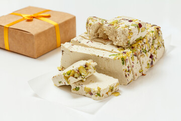 Halva with pistachios and gift box on white background