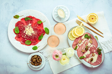 Appetizers - Vitello tonnato and beef Carpaccio with two glasses of rose wine