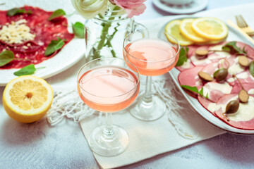 Appetizers - Vitello tonnato and beef Carpaccio with two glasses of rose wine