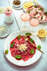 Appetizers - Vitello tonnato and beef Carpaccio with two glasses of rose wine