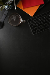 Smart watch, coffee cup, houseplant and notebook on black leather.