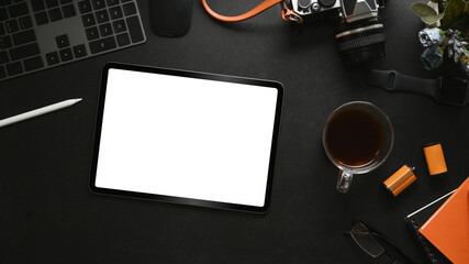 Mock up digital tablet, camera, coffee cup and notebook on black leather.