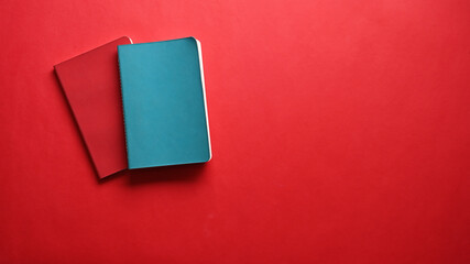 Blue and red notebook on red background. Copy space.