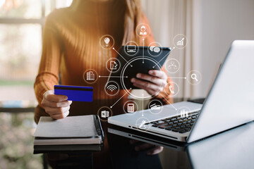 Business women use credit card to shopping online in internet website shop with computer laptop on work table in office.