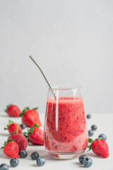 Fresh organic smoothie made from pureed raw sweet juicy red strawberries and blueberries or bog...