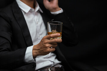 Man wearing a suit whiskey glass of liquor