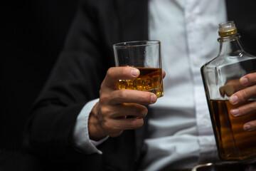 Man wearing a suit whiskey glass of liquor