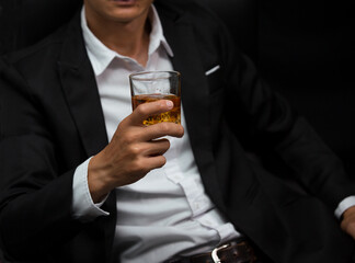 Man wearing a suit whiskey glass of liquor