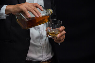 Man wearing a suit whiskey glass of liquor