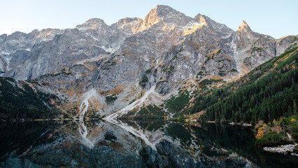 Wonderful morning view of the beautiful Lake Morskie Oko in the High Tatra Mountains. Rocks with forests are reflected in the water. Natural beauty. © WellStock