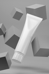 Blank white cosmetic tube on gray background.
