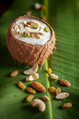 Close-up of Creamy Sabudana Kheer Garnished with dry fruits. Indian delicious dessert. Served in the coconut shell fresh green banana leaf. © Prashant ZI