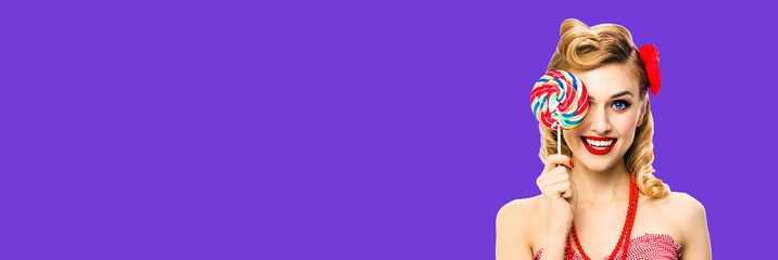 Half face portrait of excited woman with lollipop covering one eye. Pin up girl with happy smile....
