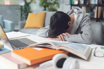 Tired student falling asleep over the desk