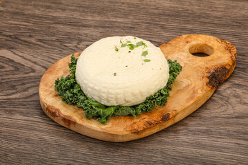 Caucasian suluguni round cheese piece