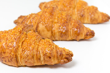 three tasty croissants on white background. French food. Close up. Diagonal