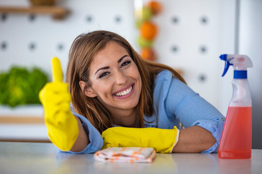 Woman doing housework, housewife portrait. Housework and housekeeping concept. Apartment cleaning. Smiling woman posing with cleaning supplies, housewife preparing detergents for housecleaning