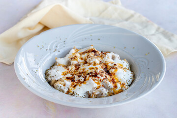 Ravioli with garlic and yoghurt on a white wooden background