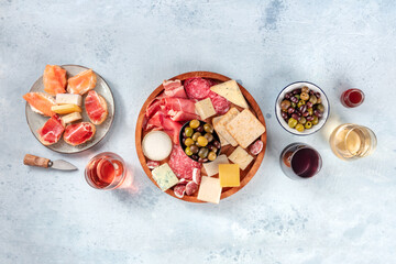 Obraz na płótnie Canvas Charcuterie and cheese board, overhead flat lay shot with copy space. Italian antipasti, shot from above with wine, olives, and sanwiches. Mediterranean delicatessen