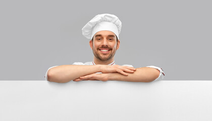 cooking, culinary and people concept - happy smiling male chef in toque with big white board over grey background