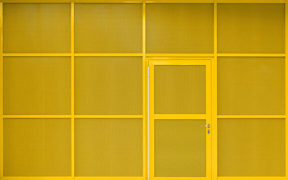 modern yellow building exterior with metallic facade and door