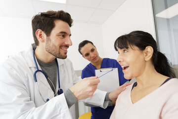 Fototapeta premium doctor examining throat of mature woman