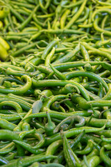 Fresh green hot peppers at the market. pepper in bulk. ripe peppers in a street market. green chili pepper
