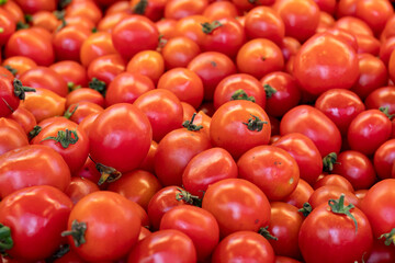 fresh cherry tomatoes in the market. cherry tomatoes in bulk. ripe cherry tomatoes in a street market