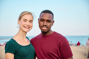 young multiethnic couple looking at camera at the beach