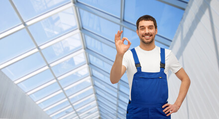 profession, construction and building concept - happy smiling male worker or builder showing ok...