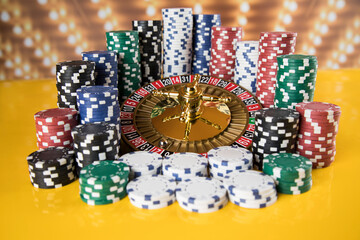 Poker Chips on gaming table, roulette wheel in motion, casino background