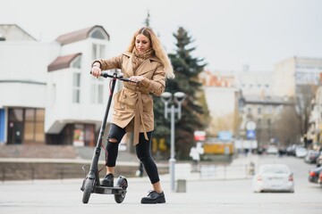 young woman on electro scooter in city. woman riding scooter in sunset light in street